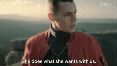 A Man In A Red Jacket Is Talking To A Woman Who Is Standing Next To Him . GIF