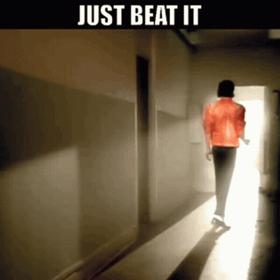 A Man In A Red Jacket Is Walking Down A Hallway With The Words Just Beat It Below Him GIF