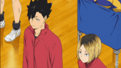 A Man In A Red Jacket Stands Next To Another Man GIF