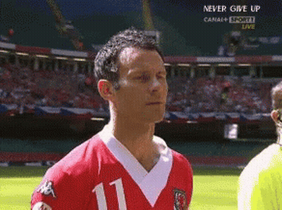 A Man In A Red Jersey With The Number 11 On It Stands On A Soccer Field GIF