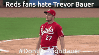 a man in a red jersey with the number 27 stands on a baseball field