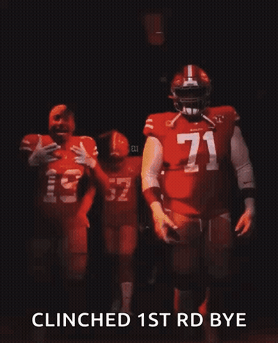 a man in a red jersey with the number 32 on it is walking in the dark .