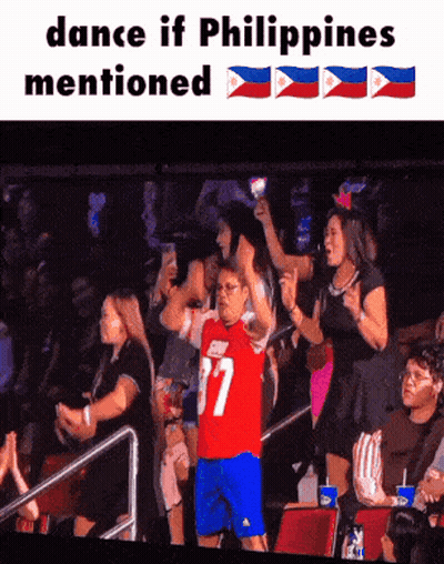 A Man In A Red Jersey With The Number 37 On It Stands In Front Of A Crowd GIF