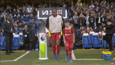 A Man In A Red Jersey With The Number 4 On It Walks With A Young Boy GIF