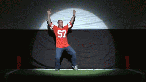 A Man In A Red Jersey With The Number 52 On It Is Dancing GIF