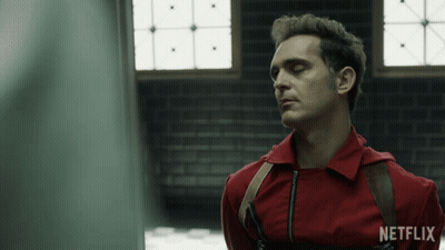 A Man In A Red Jumpsuit With A Netflix Logo On His Shirt GIF