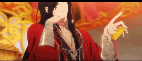 A Man In A Red Kimono Is Holding A Gold Object In His Hand . GIF