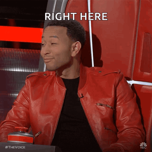 A Man In A Red Leather Jacket Sitting In A Chair With The Words Right Here Above Him GIF