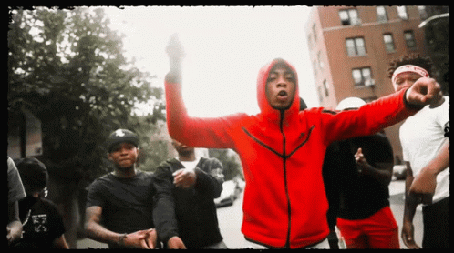 A Man In A Red Nike Jacket Stands In A Crowd GIF