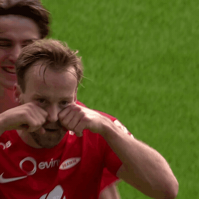 A Man In A Red Nike Jersey Is Covering His Face With His Hands While Another Man Looks On . GIF