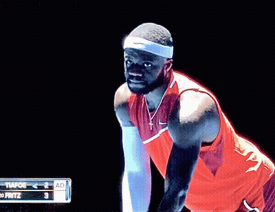 A Man In A Red Nike Shirt Is Standing In Front Of A Scoreboard That Says Fritz GIF