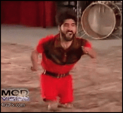 A Man In A Red Outfit Is Running In Front Of A Drum And The Words Mod Vision Are On The Bottom Of The Screen GIF