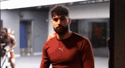 A Man In A Red Puma Shirt Stands In A Gym GIF