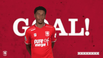 A Man In A Red Pure Energie Shirt Holds His Hands Up In The Air GIF