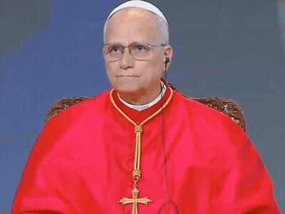 A Man In A Red Robe Has A Cross On His Neck GIF