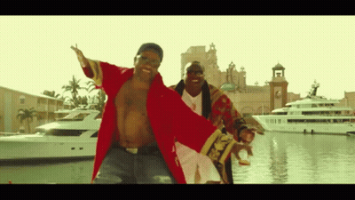 A Man In A Red Robe Is Dancing With Another Man In A Gold Robe GIF