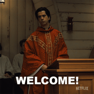 A Man In A Red Robe Is Standing In Front Of A Podium That Says Welcome Netflix GIF