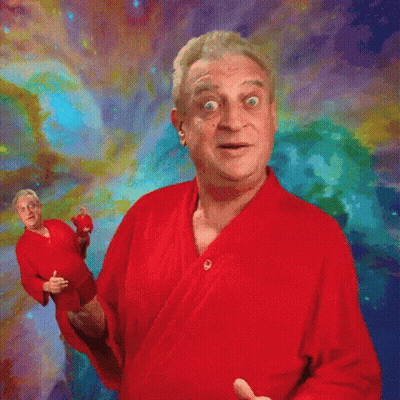 A Man In A Red Robe Stands In Front Of A Colorful Background . GIF