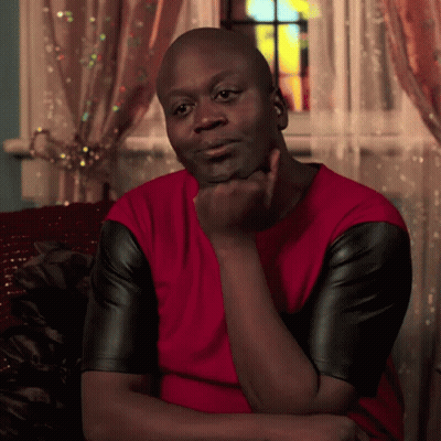 A Man In A Red Shirt And Black Leather Sleeves Is Sitting On A Couch GIF