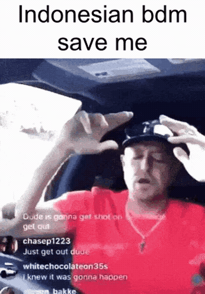 A Man In A Red Shirt And Hat Is Sitting In A Car With His Hands Up . GIF