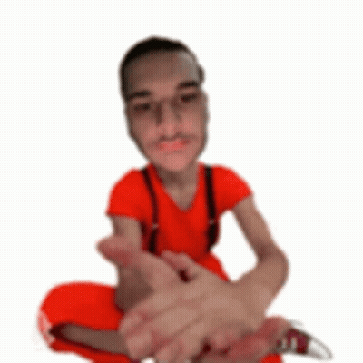 A Man In A Red Shirt And Suspenders Is Sitting On The Floor With His Legs Crossed . GIF