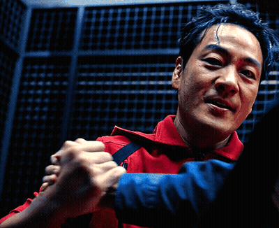 A Man In A Red Shirt Holds Another Man 'S Hand GIF