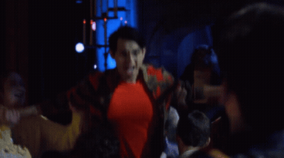 A Man In A Red Shirt Is Being Lifted By Another Man In A Yellow Jacket GIF