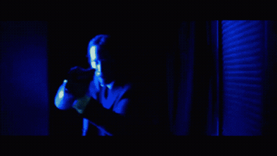 A Man In A Red Shirt Is Being Punched In The Face By Another Man In A Suit GIF