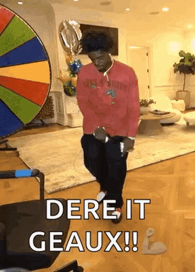 A Man In A Red Shirt Is Dancing In A Living Room In Front Of A Colorful Wheel . GIF