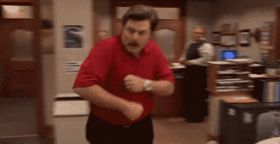 A Man In A Red Shirt Is Dancing In A Room In An Office . GIF