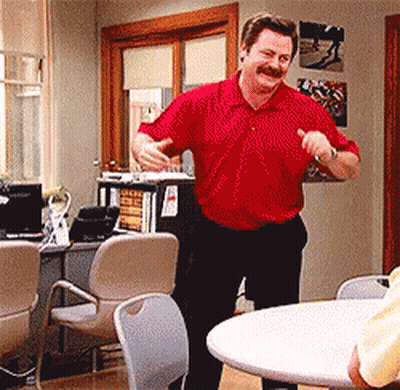 A Man In A Red Shirt Is Dancing In A Room With Chairs GIF