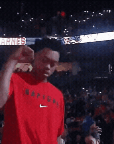 A Man In A Red Shirt Is Dancing In Front Of A Crowd With A Sign That Says Big GIF