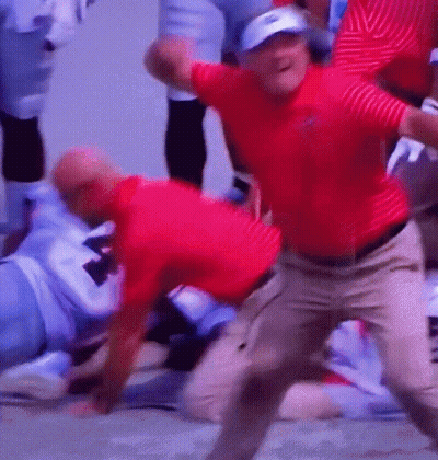 A Man In A Red Shirt Is Dancing In Front Of A Group Of People GIF