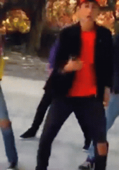A Man In A Red Shirt Is Dancing On A Ice Rink GIF