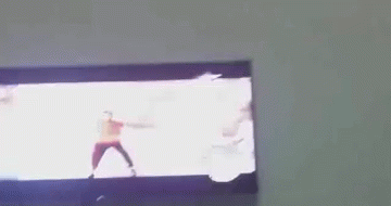 A Man In A Red Shirt Is Dancing On A Tv GIF
