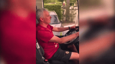 A Man In A Red Shirt Is Driving A White Car GIF