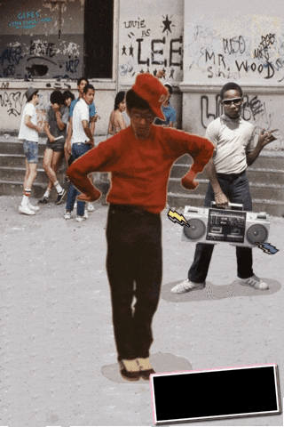 A Man In A Red Shirt Is Holding A Boombox In Front Of A Building That Has Lee Written On It GIF