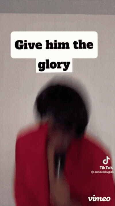 A Man In A Red Shirt Is Holding A Microphone And Says Give Him The Glory . GIF