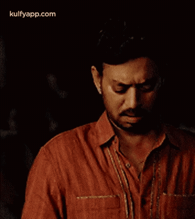 A Man In A Red Shirt Is Holding A Piece Of Paper . GIF