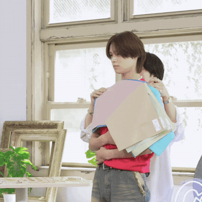 A Man In A Red Shirt Is Holding A Stack Of Paper GIF