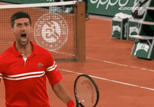 A Man In A Red Shirt Is Holding A Tennis Racquet In Front Of A Eurosport Ad GIF
