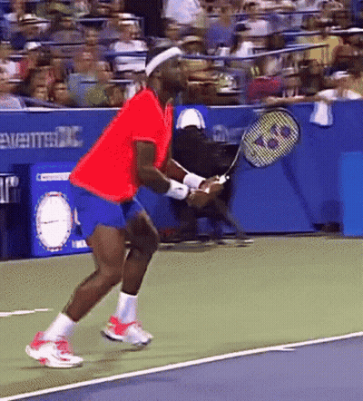 A Man In A Red Shirt Is Holding A Tennis Racquet On A Court GIF