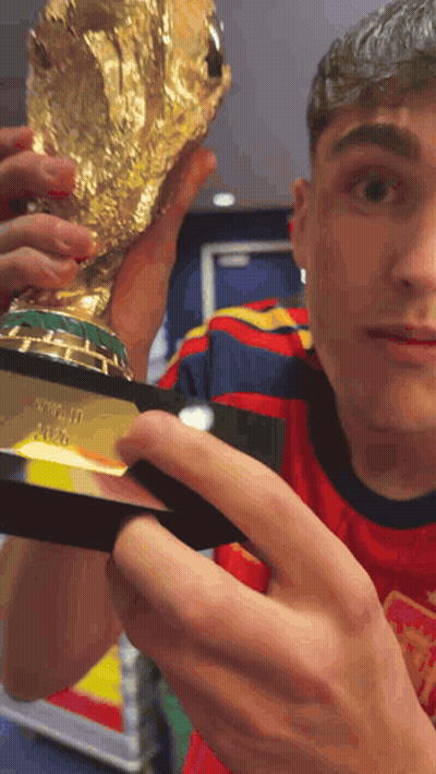 A Man In A Red Shirt Is Holding A Trophy That Says ' Fifa World Cup ' On It GIF