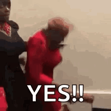 A Man In A Red Shirt Is Holding A Woman In A Red Dress And Says Yes . GIF
