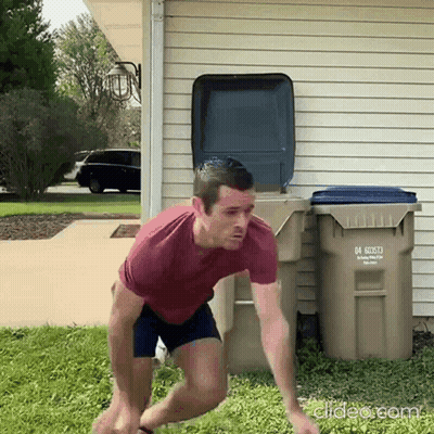 A Man In A Red Shirt Is Jumping In Front Of A Trash Can With The Number 04 On It .. GIF