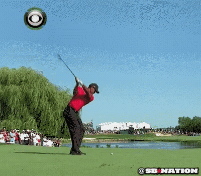 A Man In A Red Shirt Is Kneeling Down On A Golf Course With A Cbs Logo In The Background GIF