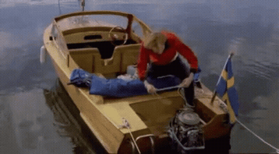 A Man In A Red Shirt Is Kneeling On A Yellow Boat GIF