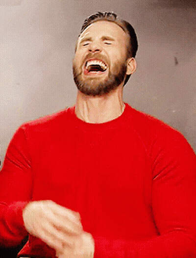 A Man In A Red Shirt Is Laughing With His Mouth Open GIF