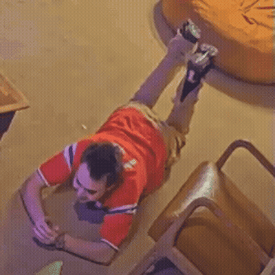 A Man In A Red Shirt Is Laying Down On The Floor GIF