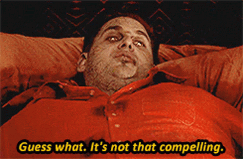 A Man In A Red Shirt Is Laying In Bed And Says Guess What It 'S Not That Compelling GIF